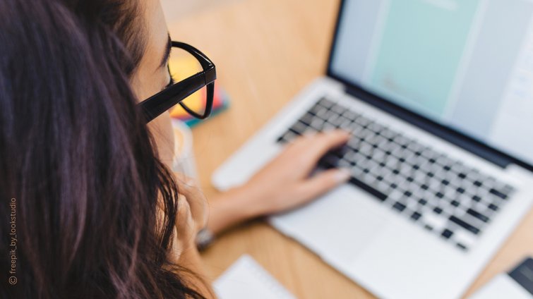 Frau am Laptop mit Brille.